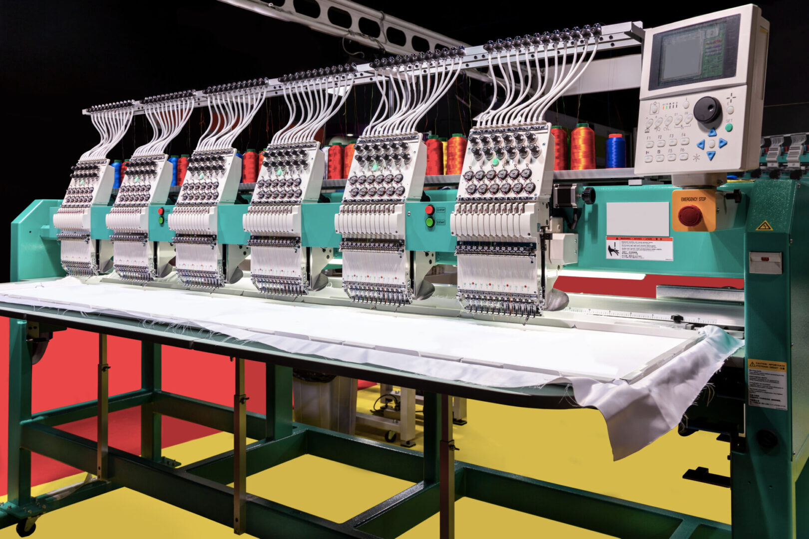 A row of embroidery machines on a table.